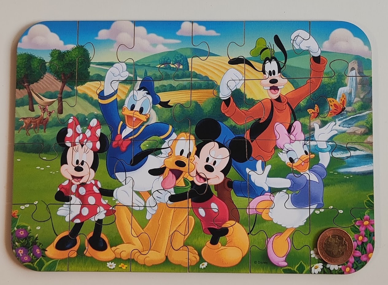 Složené dřevěné puzzle TREFL 24 dílků Mickey Mouse s padesátikorunou jako měřítkem dílku
